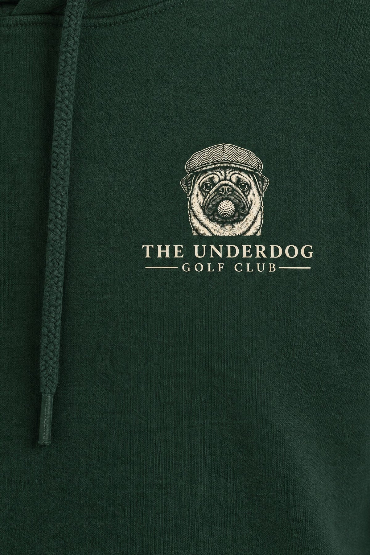 Close-up of The Underdog Golf Club pug crest printed on the left chest of the Blackish Green hoodie. Color: Blackish Green