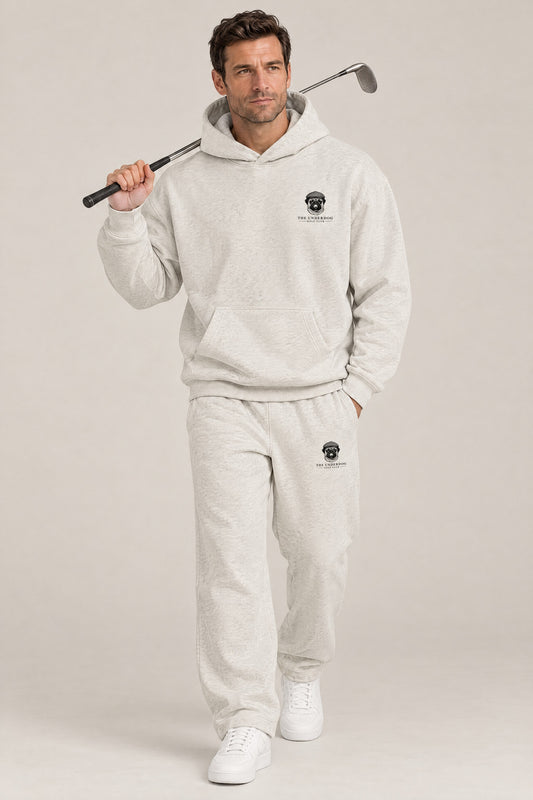 Man walking in The Heavy Hitter pug golf hoodie and sweatpants set in Oat Gray. Color: Oat Gray
