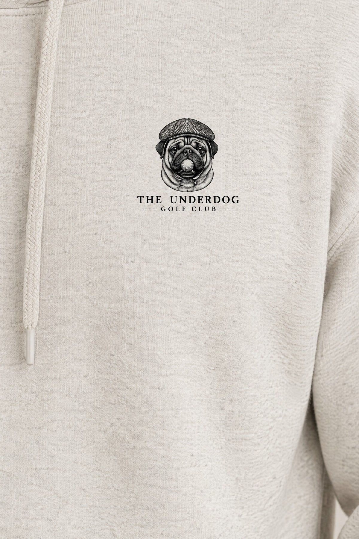 Close-up of The Underdog Golf Club pug crest printed on the left chest of the Oat Gray hoodie. Color: Oat Gray
