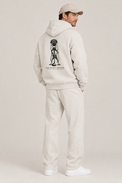 Man seen from behind in The Heavy Hitter pug golf hoodie in Oat Gray, showing the large back print. Color: Oat Gray