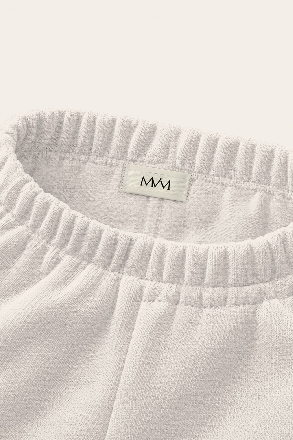 Inside of the back waistband of the oat gray Underdog Golf Club sweatpants with the MVM woven label. Color: Oat Gray