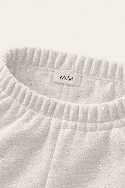 Inside of the back waistband of the oat gray Underdog Golf Club sweatpants with the MVM woven label. Color: Oat Gray