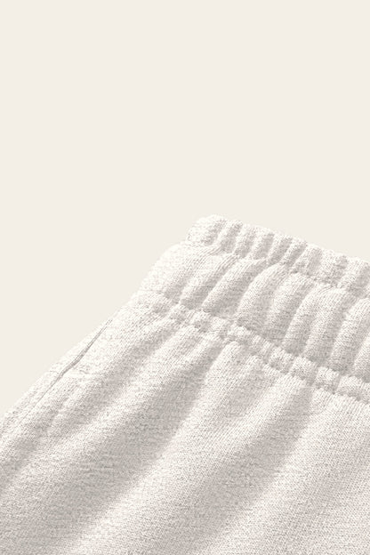 Detail of the elastic waistband and side pocket of the oat gray Underdog Golf Club sweatpants. Color: Oat Gray