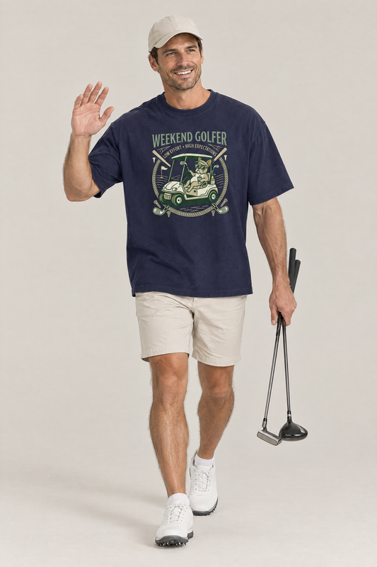 Man waving and carrying golf clubs in the navy Weekend Golfer French Bulldog Golf Tee. Color: Navy