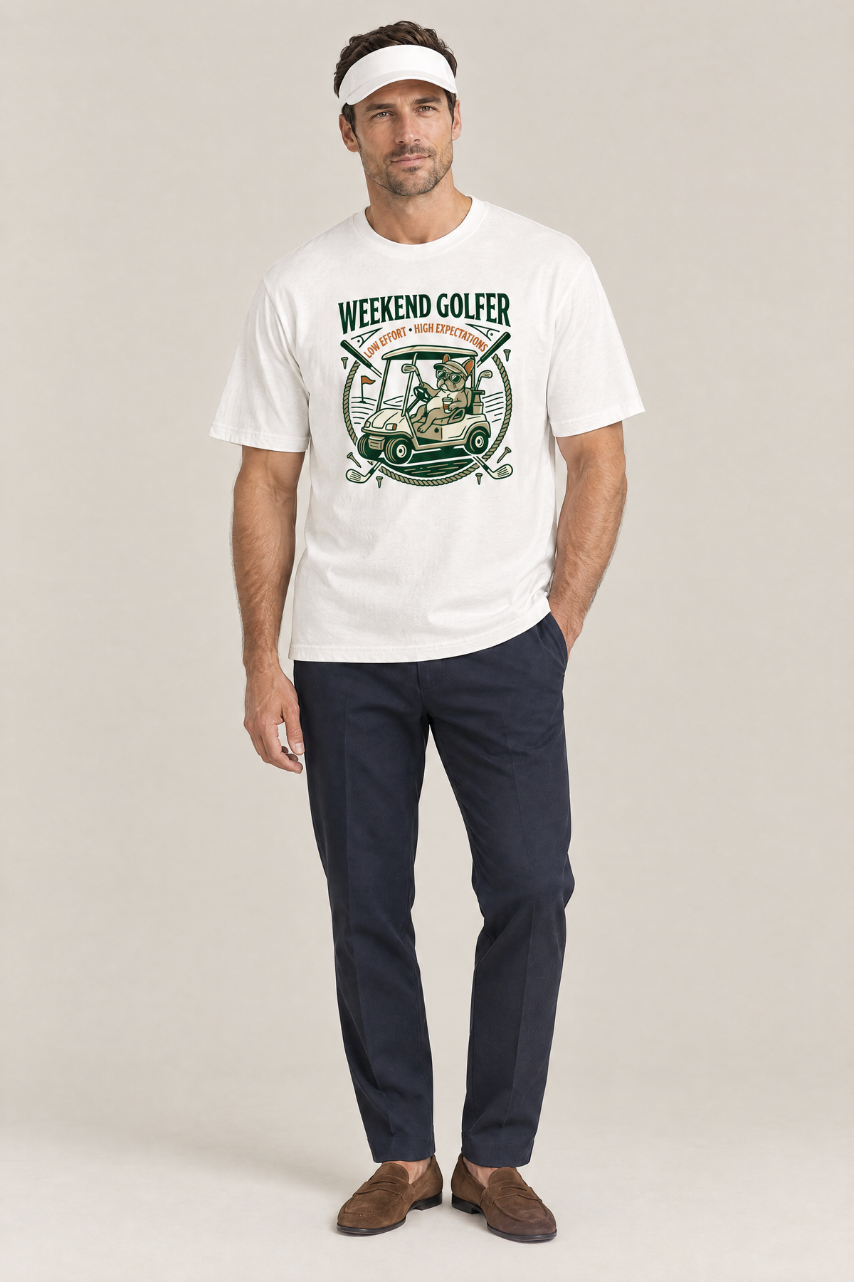Man wearing the Weekend Golfer French Bulldog Golf Tee in white with navy trousers and a white visor. Color: White