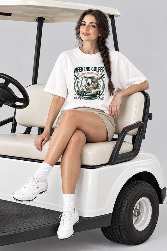 Woman sitting on a golf cart in the white Weekend Golfer French Bulldog Golf Tee and khaki golf shorts. Color: White